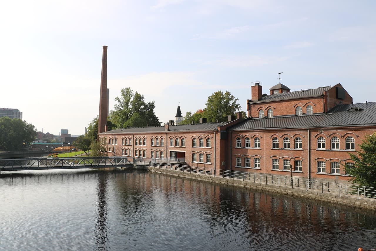 A red-brick mill and chimney beside the water
